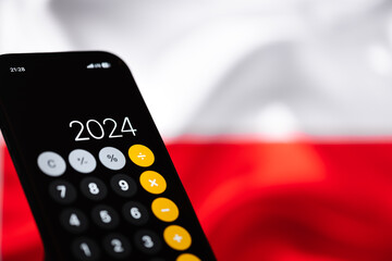 warsaw, poland - 26 07 2023: Date "2024" on the calculator in the smartphone, in the background a white and red flag of Poland (selective focus)