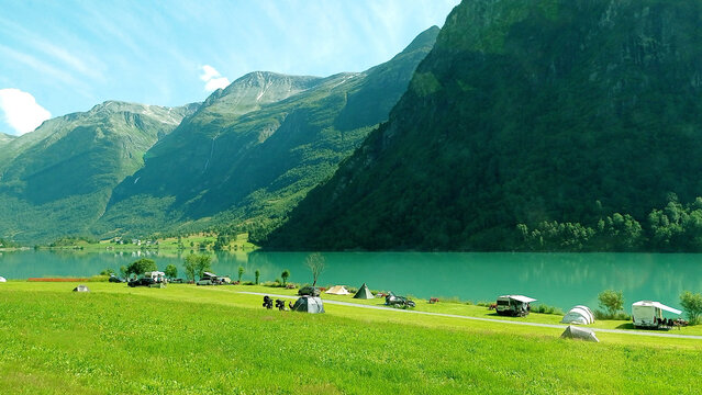 Norwegian landscape with green lake Oldevatnet in Oldedalen valley. Camping in Olden by lake Oldevatnet, Norway.