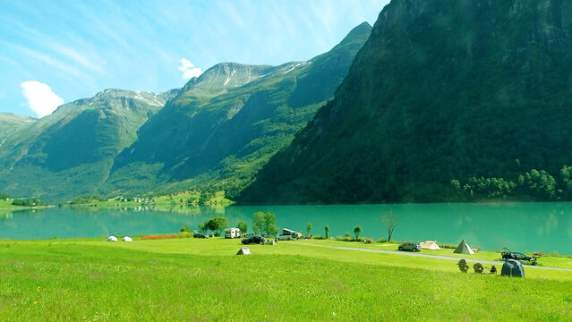 Norwegian landscape with green lake Oldevatnet in Oldedalen valley. Camping in Olden by lake Oldevatnet, Norway.