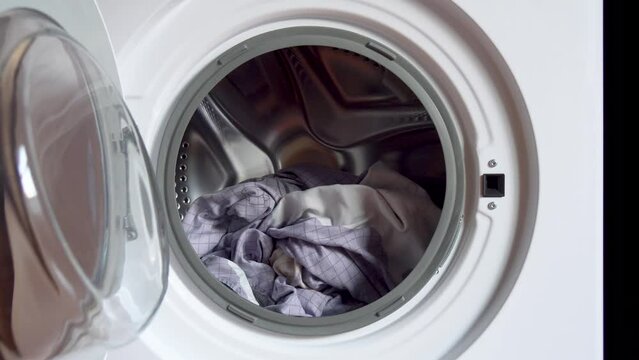 Washing clothes in a household washing machine at home. spinning drum washing machine