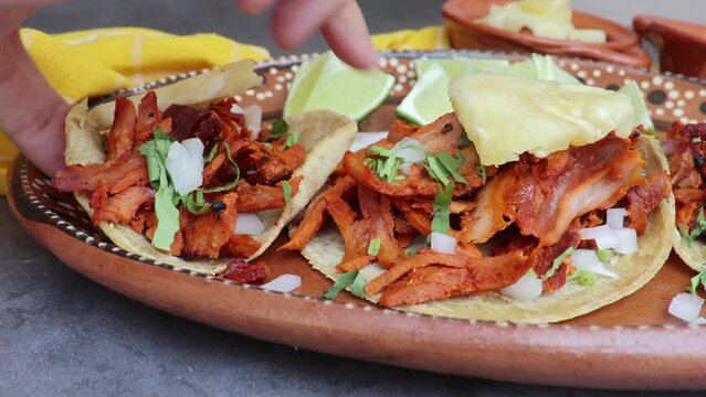 Hand ready to take Mexican taco al pastor in a traditional dish