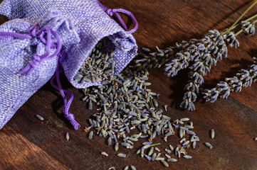 Aroma sachet with lavender flowers on a wooden background.
