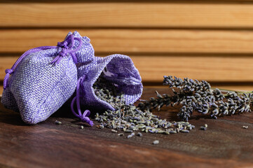 Aroma sachet with lavender flowers on a wooden background.