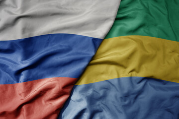 big waving realistic national colorful flag of russia and national flag of gabon .