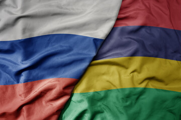 big waving realistic national colorful flag of russia and national flag of mauritius .