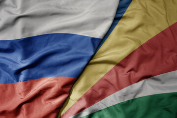 big waving realistic national colorful flag of russia and national flag of seychelles .