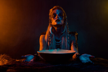 Photo of savage valkyrie potion bowl pray oden before battle orange light mist isolated on black...