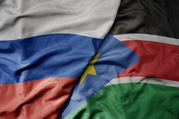 big waving realistic national colorful flag of russia and national flag of south sudan .