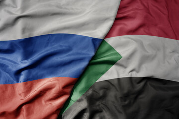 big waving realistic national colorful flag of russia and national flag of sudan .