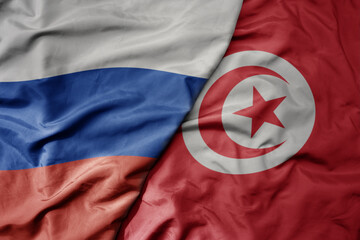 big waving realistic national colorful flag of russia and national flag of tunisia .