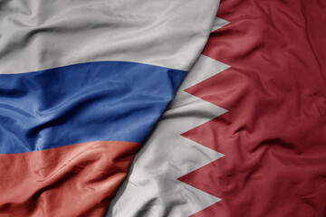 big waving realistic national colorful flag of russia and national flag of bahrain .