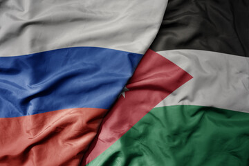 big waving realistic national colorful flag of russia and national flag of jordan .
