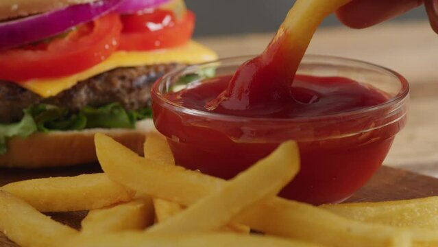 Dipping french fry into ketchup