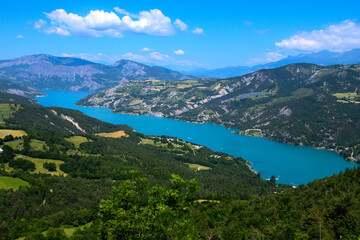 Naklejka na ściany i meble Aerial view on blue Lake of Serre-Poncon, reservoir border between Hautes-Alpes and Alpes-de-Haute Provence  departments, one of largest in Western Europe