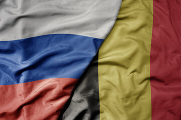 Fototapeta premium big waving realistic national colorful flag of russia and national flag of belgium .