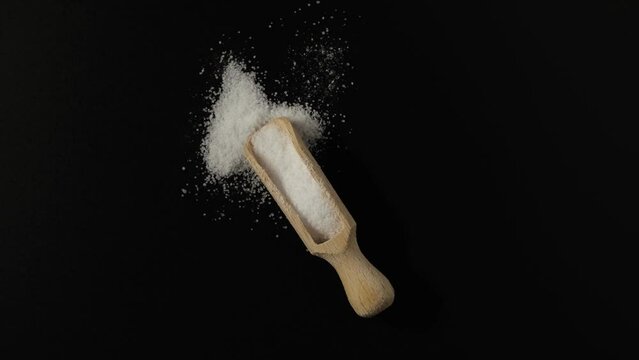 Aspartame powder in wooden scoop, top view. Video, Rotating. Food additive  E951, artificial sweetener used as sugar substitute in foods and beverages. Chemical formula	C14H18N2O5.
