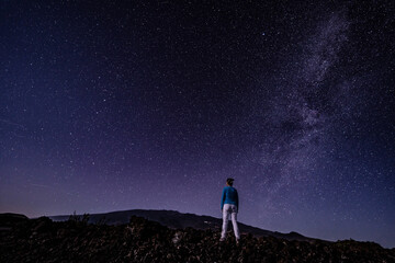 Fototapeta na wymiar Woman on the Milky Way. Stargazing at Mauna Loa Observatory Road, Big Island Hawaii. Starry night sky, galaxy astrophotography. Mauna kea