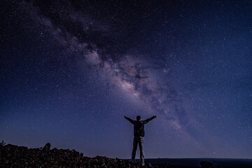 Men / boy on the Milky Way. Stargazing at  Mauna Loa Observatory Road, Big Island Hawaii. Starry night sky,  galaxy astrophotography. 