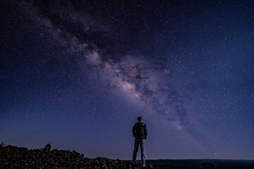 Silhouette of Men / boy on the Milky Way. Stargazing at  Mauna Loa Observatory Road, Big Island Hawaii. Starry night sky,  galaxy astrophotography. 