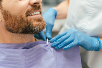 Closeup, selective focus on man's teeth. Smiling male patient sitting in dental chair, treatment