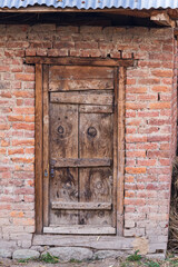 A weathered wooden door in a brick wall.