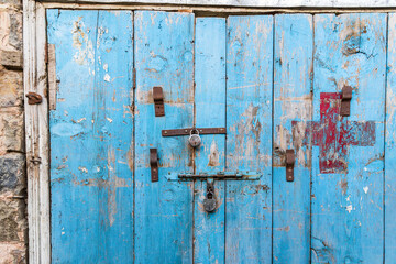 Padlocks on a weathered blus door.