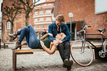 Mature couple sitting on a bench after riding bikes in the city