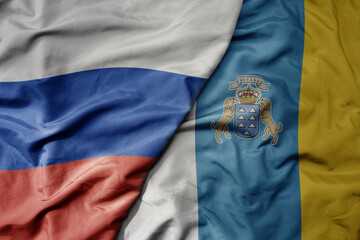 big waving realistic national colorful flag of russia and national flag of canary islands .