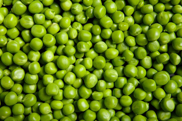 Background of fresh organic sweet green peas, pea grains close-up, top view.