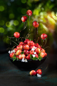 Cherries in bowl levitating with juice 