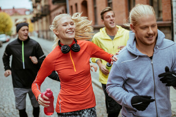 Young people jogging on a city street together