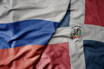 big waving realistic national colorful flag of russia and national flag of dominican republic .