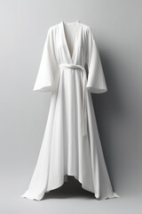 A white robe is hanging on a wall. Digital image.