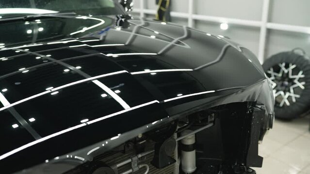 Film on the body of the car. Detailing - service, maintenance of a black car. Vehicle detailing.