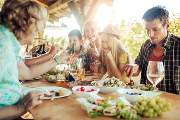 Multigenerational family enjoying a family lunch on a patio at a vineyard