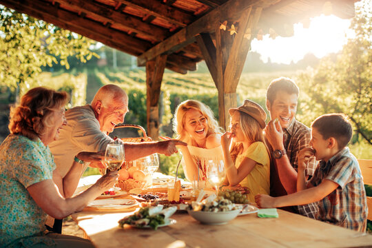 Multigenerational Family Having A Family Lunch Outdoors On A Patio