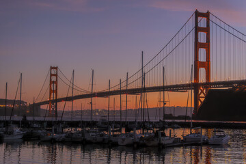 Golden Gate Bridge at sunset with marina in foreground and pink clouds