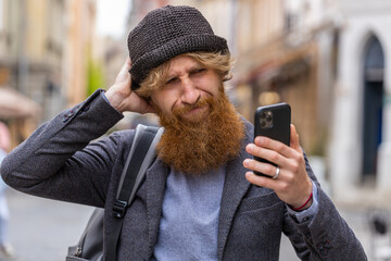 Surprised bearded man use smartphone typing browsing, loses becoming surprised sudden lottery...
