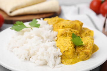 Delicious rice and chicken with curry sauce on plate, closeup