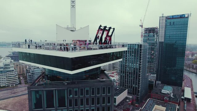 People enjoying the view and swinging on a swing on a viewpoint in Amsterdam. High quality 4k footage