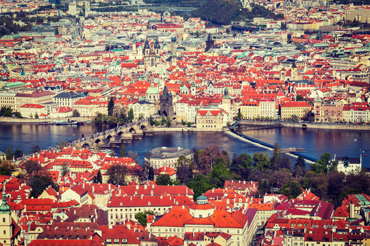 Vintage retro hipster style travel image of aerial view of Charles Bridge over Vltava river and Old city from Petrin hill Observation Tower. Prague, Czech Republic