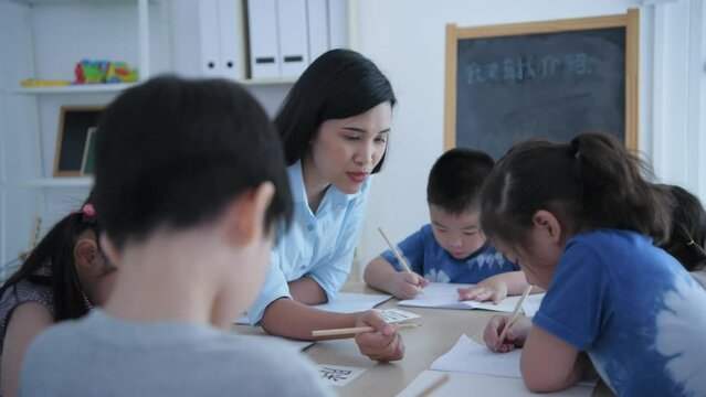 (Chinese wording translation:insect, introduction) Educational concept of 4k Resolution. The teacher is teaching children to learn Chinese in the classroom.