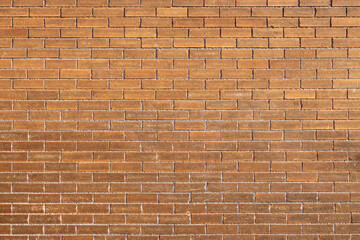 Full frame texture background of a grungy antique orangish brown brick wall in a running bond brickwork style