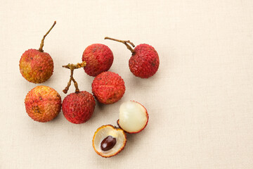 Fresh ripe red lychee fruit and peeled lychee on the table
