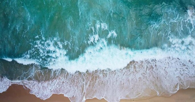 Coastal Phuket Thailand, as monsoon storms surpass high waves, top-down view aerial video, huge sea waves rolling into sandy beach at Andaman sea Filmed with high quality film cameras. DCI 4K ProRes