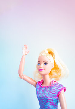 片手を上に挙げるジェスチャーをしているバービー人形 - 挨拶や挙手する女性のイメージ素材
