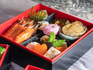 日本のお節料理。お正月の伝統料理。鮑やえびや煮物が入った重箱。