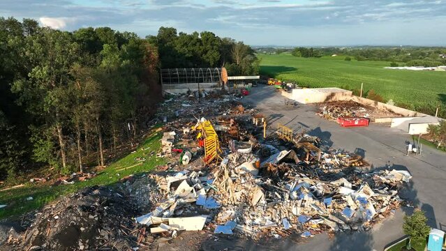 Rubble and debris from building fire. USA township municipality building with heavy equipment exploded from propane gas leak. Aerial establishing shot.