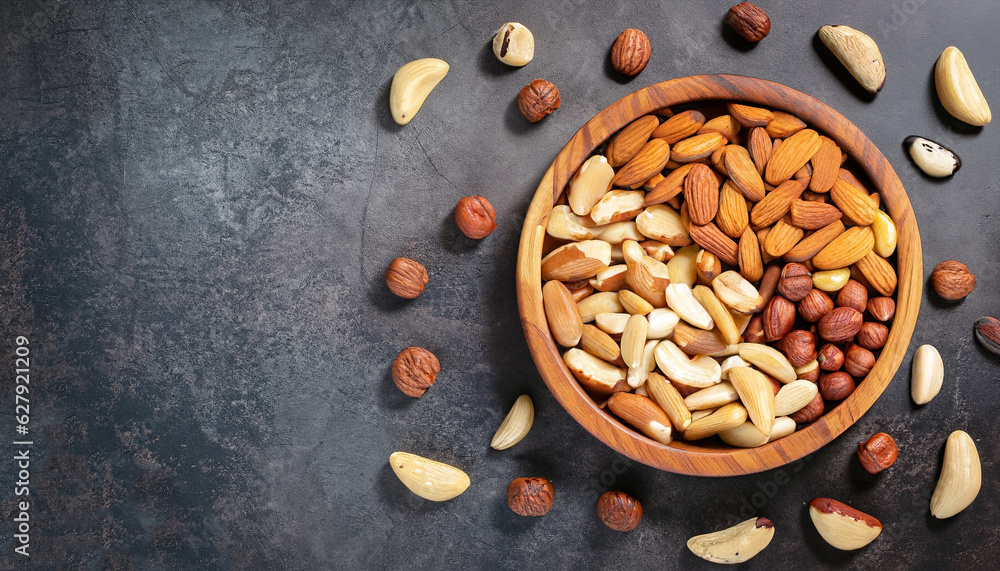 Sticker assortment of nuts in wooden bowl on dark stone table. cashew, hazelnuts, walnuts, almonds, brazilia - Stickers