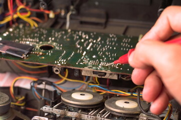 Fototapeta na wymiar Repairman repairing electronic circuit board with red pen, close-up